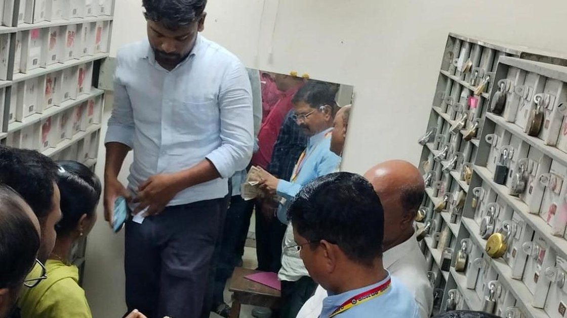 लोकायुक्त अधिकारी कालाबुरगी में एसबीआई बैंक लॉकर से विमुद्रीकृत नोटों की गड्डियां निकालते हुए