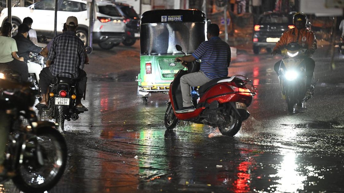 हैदराबाद में बारिश के दौरान सिकंदराबाद में सड़क पर चलते लोग