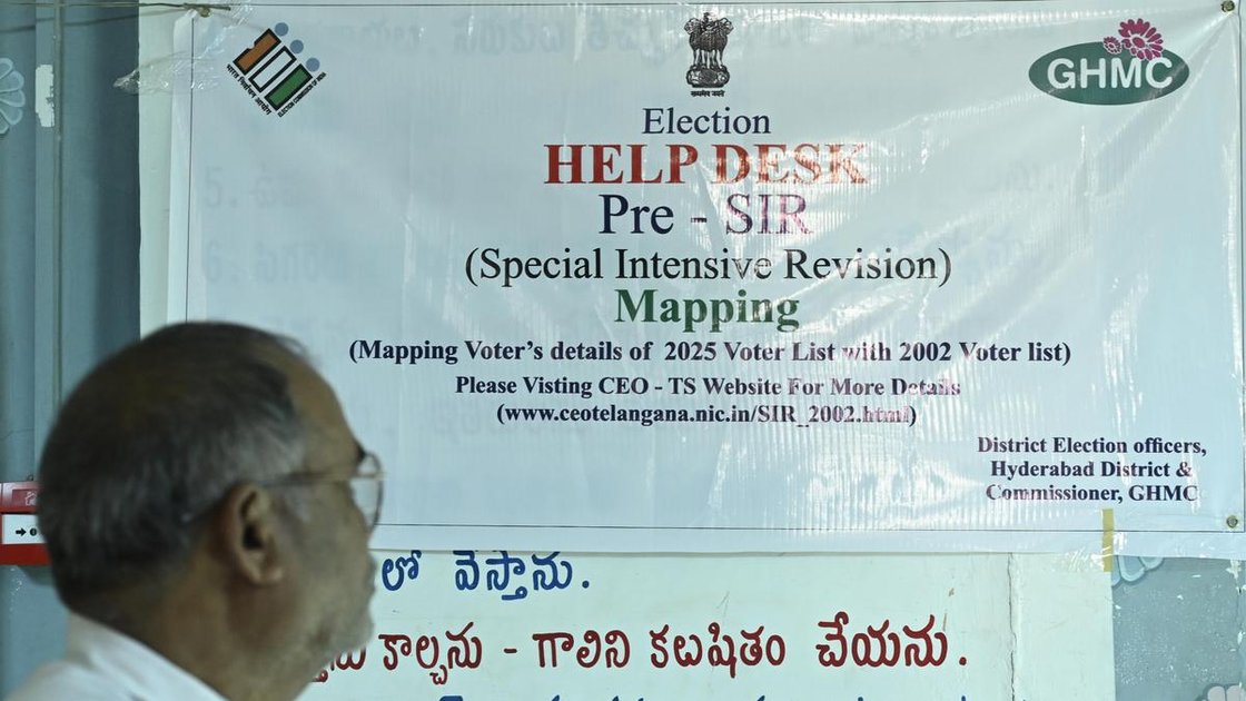 A voter looks at a Special Intensive Revision (SIR) help desk banner at a GHMC office in Hyderabad.