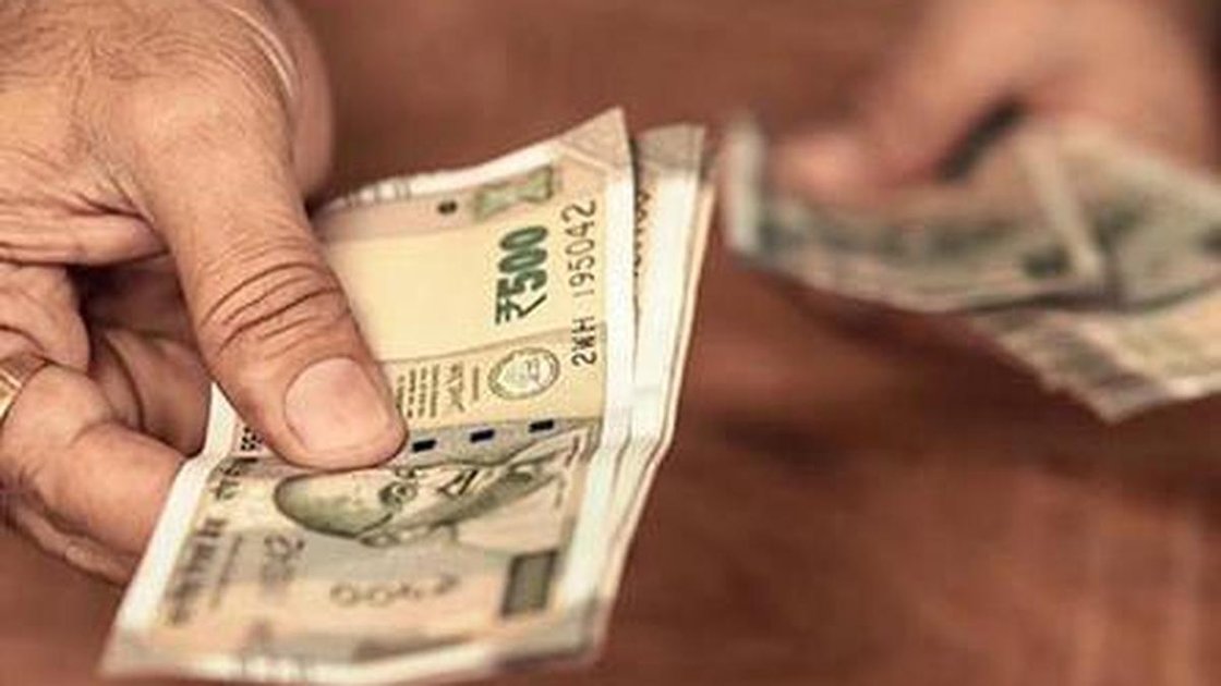 Representative image of a bribery handshake with money