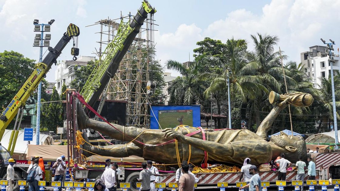 Workers shifting a large statue of Lionel Messi on a trailer in Kolkata on June 1, 2026