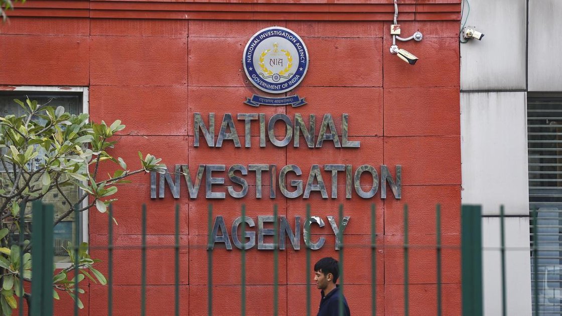 NIA officials outside a house in Amritsar during property attachment