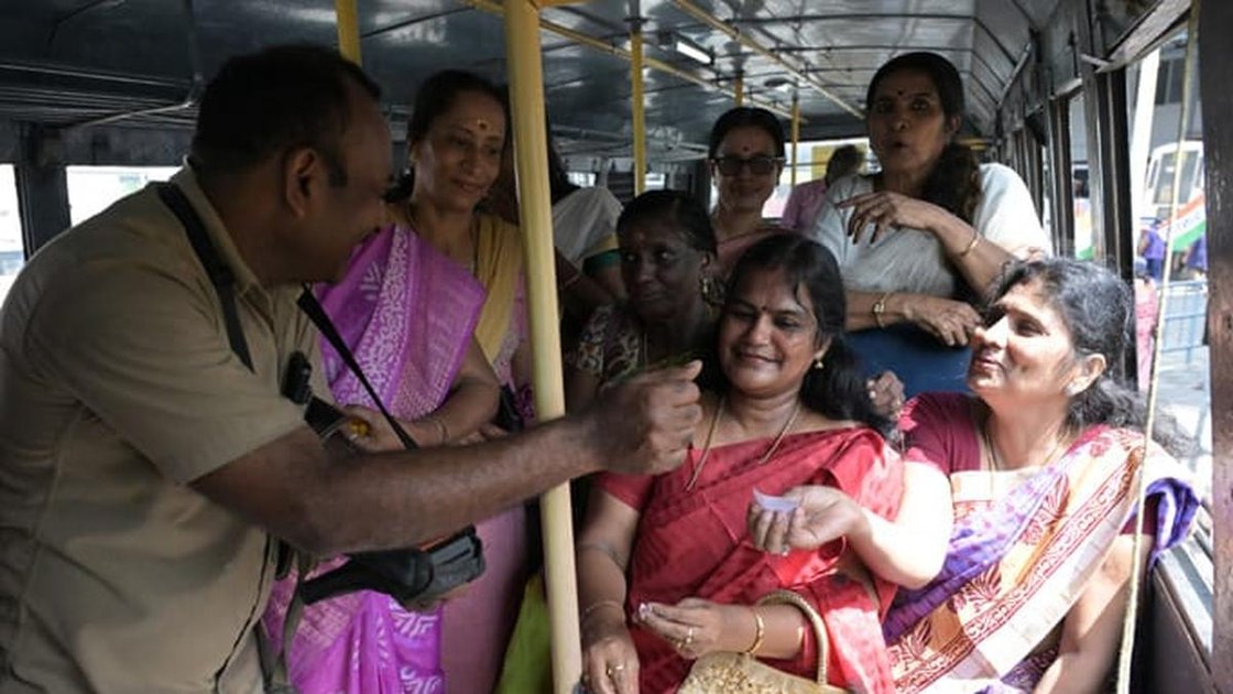 केरल में KSRTC बस में महिलाओं को मुफ्त यात्रा टिकट वितरित करता कंडक्टर